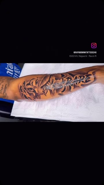 Tiger and lettering forearm tattoo by Bamz