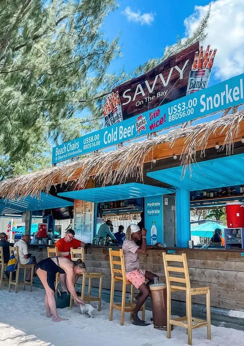 The turquoise beach bar and wooden stools at Savvy On The Bay